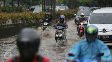 Sejumlah kendaran mencoba menerobos genangan air di kawasan Kuningan, Jakarta, Selasa (24/11). Jalur lambat di Jalan HR Rasuna Said, Kuningan, tampak dihindari pengendara karena terdapat genagan air setinggi 20 cm. (Liputan6.com/Faizal Fanani)