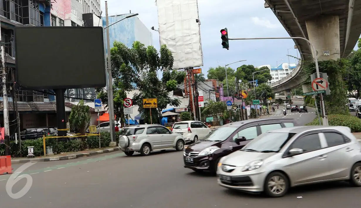 Sejumlah mobil melintas di dekat sebuah videotron di simpang Jalan Iskandarsyah, Jakarta Selatan, Minggu (2/10). Garis polisi terpasang terkait insiden videotron yang memutar video porno pada Jumat, 30 September 2016 lalu. (Liputan6.com/Helmi Afandi)