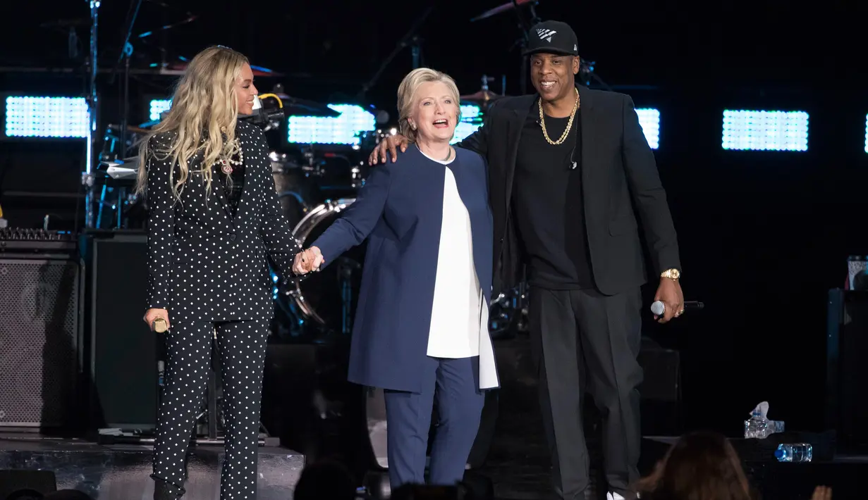 Penyanyi Beyonce dan suaminya, Jay Z berdiri bersama Capres AS Hillary Clinton dalam konser kampanye di Cleveland, Ohio, Jumat (4/11). Jay Z dan Beyonce menggelar konser bagi Hillary untuk meraih pemilih muda berkulit hitam di Ohio. (AP Photo/Matt Rourke)