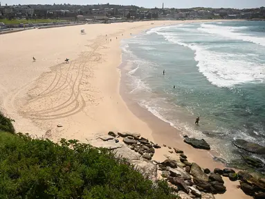 Pantai Bondi yang kosong setelah pemerintah menutup pantai paling populer di Sydney, Minggu (22/3/2020). Otoritas Australia menutup Bondi Beach  lantaran orang-orang mengabaikan larangan pemerintah untuk tidak berkumpul dalam jumlah besar guna menekan penyebaran virus corona. (PETER PARKS/AFP)