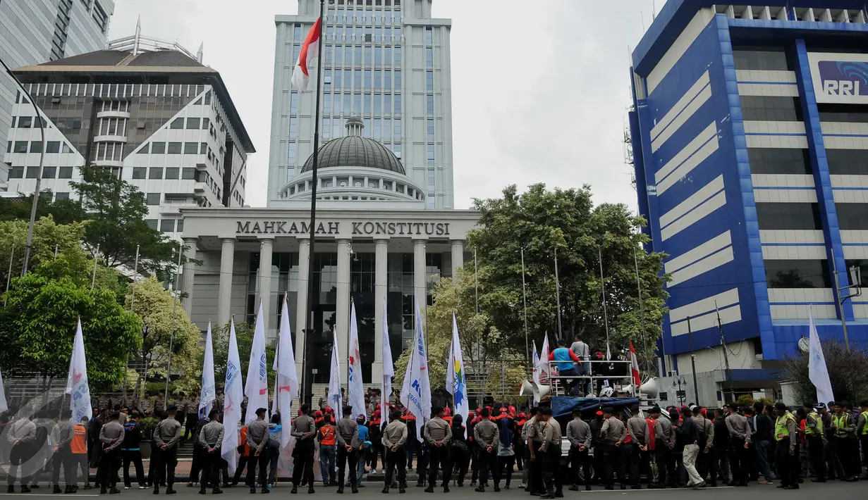 Personel kepolisian mengawal unjuk rasa ratusan buruh dari Konferederasi Serikat Pekerja Indonesia di depan Gedung MK Jakarta, Jumat (22/7). Mereka mengajukan berkas gugatan uji materi atas UU Pengampunan Pajak (Tax Amnesty). (Liputan6.com/Gempur M Surya)