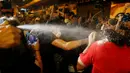 Polisi menggunakan semprotan merica untuk menghadapi pengunjuk rasa yang berdemonstrasi di Hong Kong, Minggu (6/10). Massa menentang intervensi Bejing untuk melarang dua aktivis pro-kemerdekaan menjabat sebagai anggota parlemen. (REUTERS/Tyrone Siu)