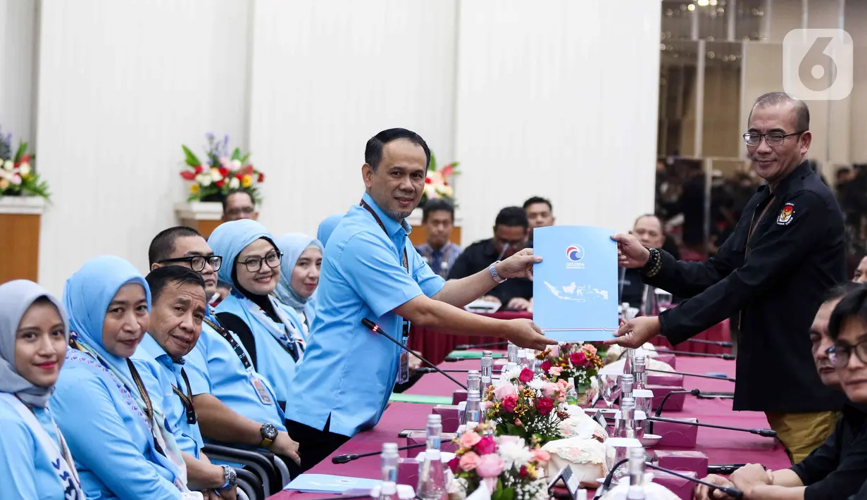 Sekjen Partai Gelora Mahfudz Siddiq menyerahkan dokumen daftar bakal calon legislatif (bacaleg) kepada Ketua Komisi Pemilihan Umum (KPU) Hasyim Asy'ari di Gedung KPU, Jakarta, Minggu (14/5/2023).  (Liputan6.com/Herman Zakharia)