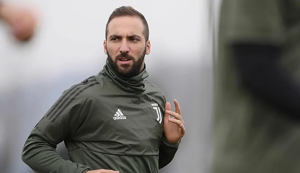 Penyerang Juventus, Gonzalo Higuain melakukan pemanasan saat sesi latihan di pusat pelatihan Juventus di Vinovo (2/4). Juventus akan bertanding melawan Real Madrid pada leg pertama babak perempatfinal Liga Champions. (AFP Photo/Marco Bertorello)