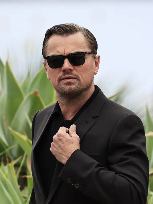 Aktor Hollywood berusia 48 tahun ini tampil necis dengan setelan jas dan celana panjang berwarna senada, dipadukan dengan kemeja hitam. (AFP/Valery Hache)