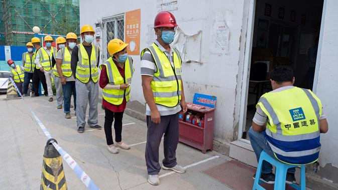 Para pekerja konstruksi berbaris mengantre di lokasi pengambilan sampel sementara di Distrik Daxing, Beijing, China (2/7/2020). Sebanyak 1.353 pekerja di lokasi konstruksi tersebut menjalani pengambilan sampel tes asam nukleat pada Kamis (2/7). (Xinhua/Cai Yang)