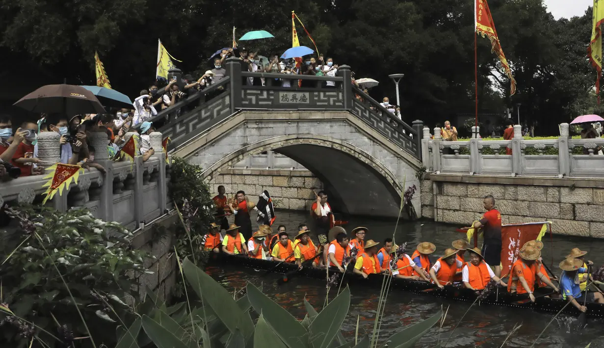 Peserta perahu naga dari desa Panting mendayung di sepanjang kanal di kawasan bersejarah Teluk Lychee di Guangzhou di Provinsi Guangdong, China selatan, Jumat, 3 Juni 2022. Perlombaan perahu naga kembali digelar di beberapa bagian China untuk pertama kalinya sejak merebaknya pandemi pada akhir 2019, saat pembatasan dicabut bersama dengan penurunan besar  kasus COVID-19. (AP Photo/Caroline Chen)