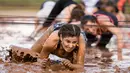 Sejumlah peserta merangkak di kolam lumpur saat mengikuti Mud Day di Tel Aviv, Israel (16/3). Dalam acara ini para peserta harus melewati rintangan sepanjang 13 kilometer. (AFP Photo/Jack Guez)