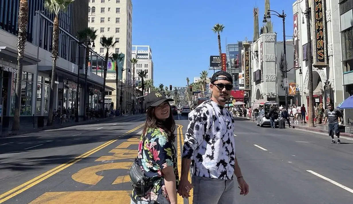 Masih di Amerika, Denny dan Olivia sama-sama mengenakan atasan bercorak dipadukan celana pendek dan sepatu sneakersnya. Lengkap dengan topinya. [@sumargodenny]