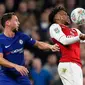 Pemain Arsenal, Alex Iwobi mengendalikan bola di depan pemain Chelsea, Danny Drinkwater pada laga semifinal pertama Piala Liga Inggris di Stadion Stamford Bridge, Rabu (10/1). Chelsea dan Arsenal bermain imbang tanpa gol. (AP/Kirsty Wigglesworth)