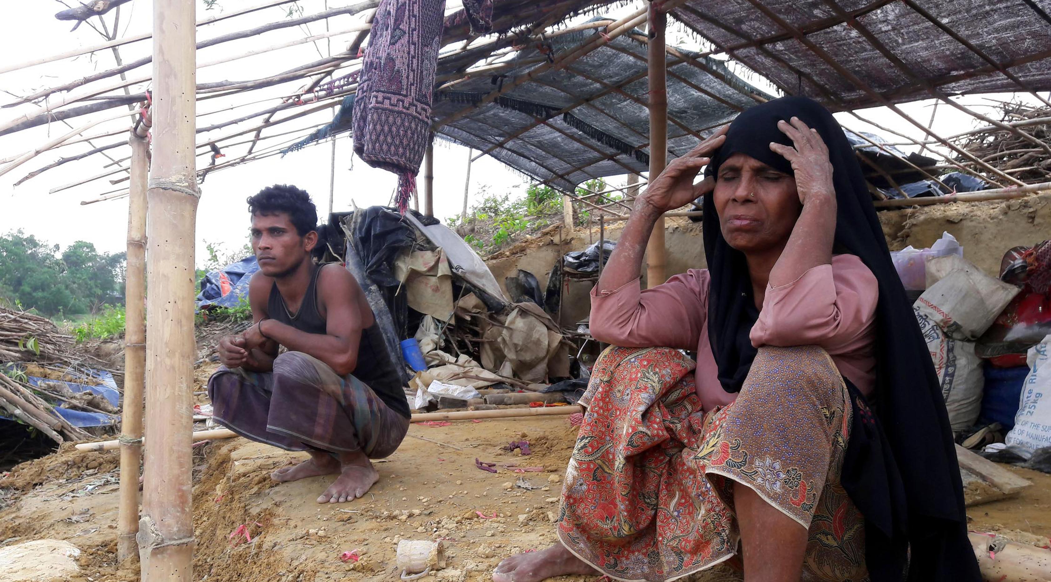 Pengungsi Rohingya duduk di sebuah tenda yang rusak akibat dihantam Topan Mora di sebuah kamp di distrik Cox's Bazar, Bangladesh (31/5). Ribuan rumah dan tenda-tenda yang beratap jerami di kamp tersebut hancur akibat Topan Mora. (AFP Photo/Str)