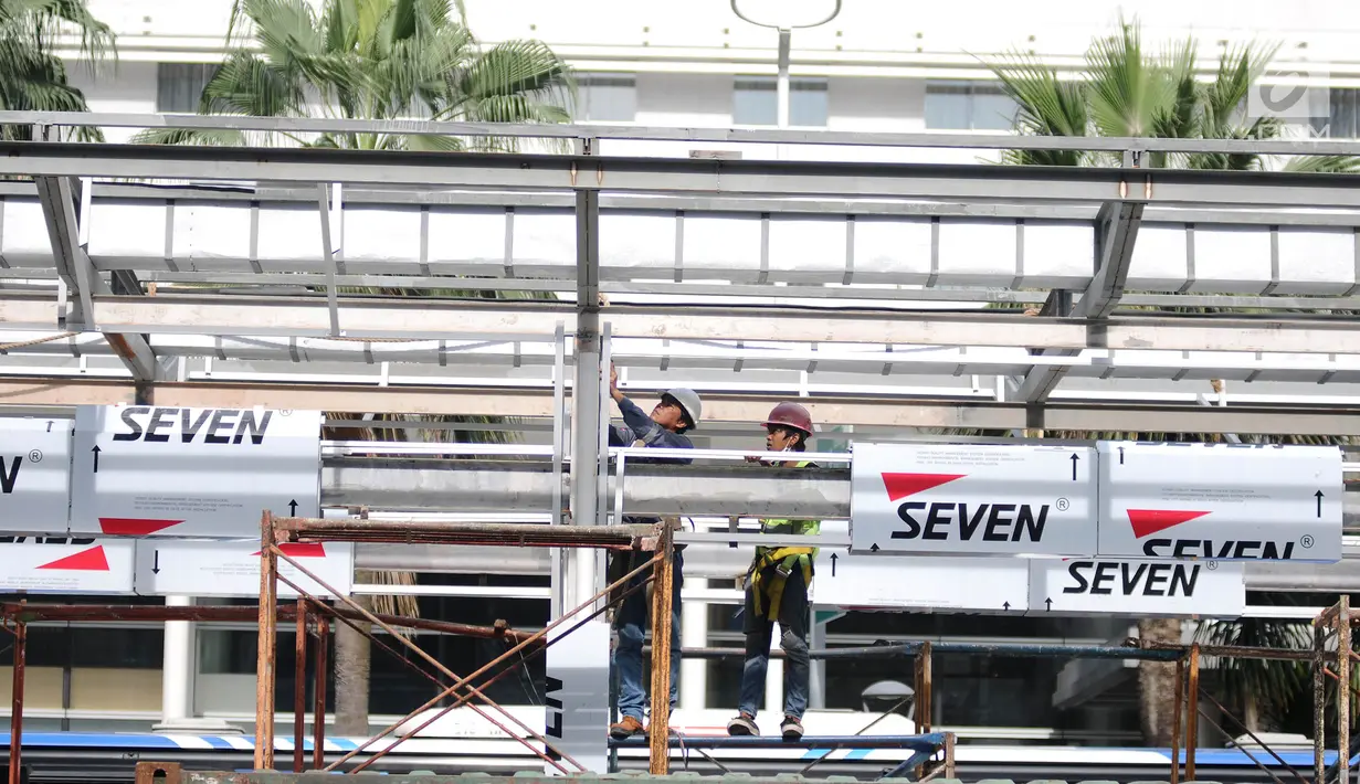 Pekerja menyelesaikan proyek pembangunan Halte Transjakarta Bundaran HI di Jakarta, Sabtu (9/3). Setelah sempat dibongkar untuk proyek MRT, Pemprov DKI kembali membangun Halte Transjakarta Bundaran HI. (Liputan6.com/Herman Zakharia)