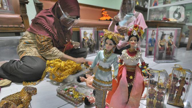 Ibu rumah tangga menyelesaikan pembuatan boneka adat Indonesia di Ammie Dolls, Kawasan Depok, Kamis (13/08/2020). UMKM binaan Pertamina ini sebelum masa pandemi mampu menghasilkan 200 pasang boneka tiap bulannya dengan harga antara 135 ribu hingga Rp 200 ribu per pasang. (merdeka.com/Arie Basuki)