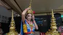 Seorang penari Thailand yang mengenakan pelindung wajah merapikan kostum di Kuil Erawan di Bangkok, pada 4 Mei 2020. Penampilan tari tersebut dilakukan setelah Pemerintah Thailand melonggarkan aturan pembatasan terkait penyebaran virus corona. (Xinhua/Rachen Sageamsak)