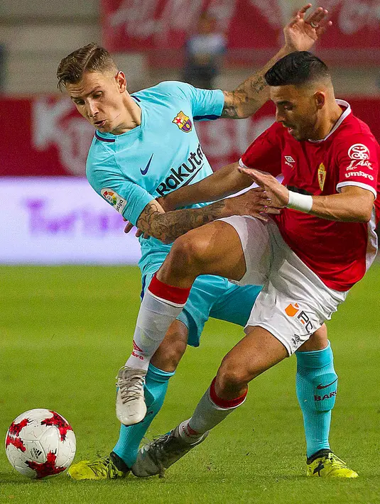 Pemain Barcelona, Lucas Digneberebut bola dengan pemain Real Murcia, Nadjib Montes pada leg pertama 32 besar Piala Raja di stadion Nuevo Condomina, Rabu (25/10). Tanpa Lionel Messi dan Luis Suarez, Barcelona menggasak tuan rumah, 3-0. (AP/Ferran Viros)