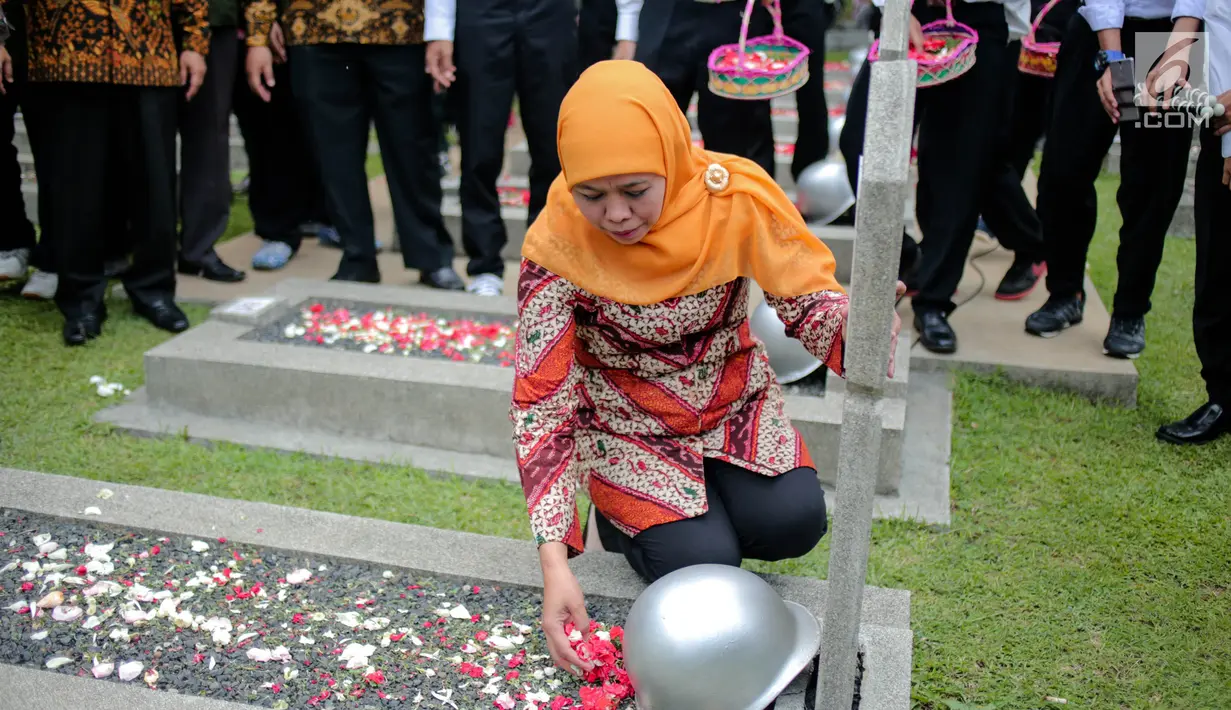 Menteri Sosial Khofifah Indar Parawansa menaburkan bunga di salah satu makam pahlawan di Taman Makam Pahlawan Kalibata, Jakarta, Senin (2/10). Mensos mengajak 50 santri penghafal Alquran untuk mendoakan para pahlawan nasional. (Liputan6.com/Faizal Fanani)