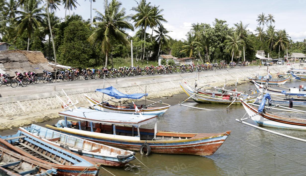 Perahu Nelayan saat dilintasi oleh para pebalap pada etape ke-5 Tour de Singkarak dari Pantai Carocok-Painan menuju pantai Gondoriah-Pariaman, Sumatera Barart. (Bola.com/Nicklas Hanoatubun)