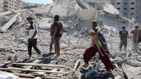 Kantor Media Pemerintah Gaza melaporkan agresi Israel yang kini memasuki hari ke-730 sejak dimulainya perang pada 7 Oktober 2023 telah menyebabkan lebih dari 67.000 warga Palestina gugur dan ratusan ribu lainnya luka-luka. Sementara itu, 90 persen wilayah Gaza nyaris rata dengan tanah akibat serangan udara dan darat Israel. Tampak dalam foto, seorang perempuan Palestina menggendong seorang anak sambil berjalan di antara reruntuhan dekat Menara Tiba yang runtuh beberapa saat setelah serangan Israel menargetkan gedung tinggi tersebut di Kota Gaza pada 10 September 2025. (Omar AL-QATTAA/AFP)