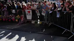 Sejumlah orang menghadiri aksi solidaritas di Albert Square, pusat kota Manchester, sehari setelah teror bom bunuh diri saat konser Ariana Grande, Selasa (23/5). Mereka membawa bendera kecil, poster bertuliskan I Love MCR. (AP Photo / Kirsty Wigglesworth)