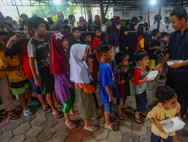 Anak-anak dan warga antre mendapatkan makanan pembuka puasa (takjil) di halaman Masjid Wihdatul Ummah, Limo, Depok, Senin (1/4/2024). (merdeka.com/Arie Basuki)