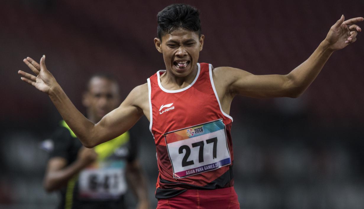 Pelari Indonesia, Sapto Yogo Purnomo, melakukan selebrasi usai meraih medali emas cabang atletik nomor lari 200 meter T 37 Asian Para Games di SUGBK, Jakarta, Senin (8/10/2018). (Bola.com/Vitalis Yogi Trisna)