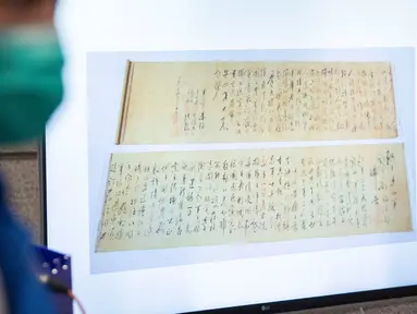Polisi menunjukkan gambar gulungan kaligrafi karya Mao Zedong, yang telah ditemukan, pada konferensi pers di Hong Kong, 7 Oktober 2020. Gulungan kaligrafi karya tokoh pendiri Republik Rakyat China, yang bernilai sekitar USD300 juta itu hilang dicuri pada September tahun lalu. (ISAAC LAWRENCE/AFP)