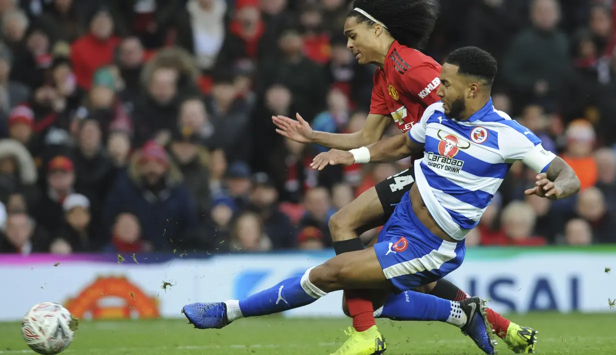 Pemain Manchester United, Tahiht Chong, berebut  bola dengan pemain Reading, Liam Moore, pada laga Piala FA di Stadion Old Trafford, Sabtu (5/1). Manchester United menang 2-0 atas Reading. (AP/Rui Vieira)
