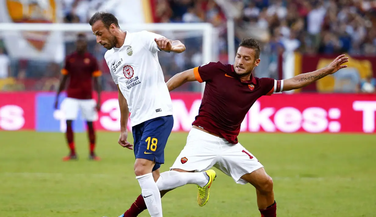 Kapten tim AS Roma, Francesco Totti (kanan), berusaha merebut bola dari kaki Vangelis Moras (Hellas Verona) saat berlaga dilanjutan Serie A Italia di Stadion Olimpiade, Roma (27/9/2014). AS Roma unggul dua gol atas Hellas Verona. (REUTERS/Tony Gentile)