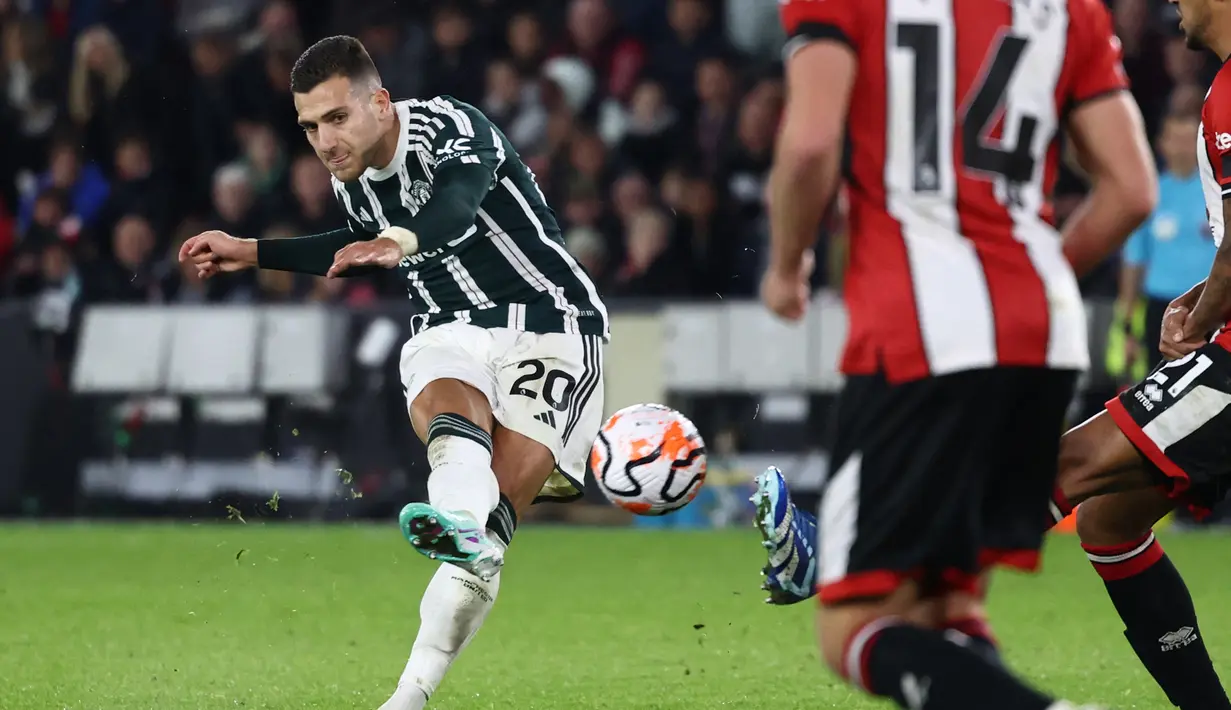 Pemain MU, Diogo Dalot (kiri), menendang bola ke gawang Sheffield United yang membuahkan gol dalam laga pekan ke-9 Premier League 2023/2024 yang berlangsung di Bramall Lane, Inggris, Minggu (22/10/2023). (AFP/Darren Staples)