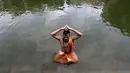 Umat Hindu duduk dalam kolam saat melakukan ritual selama gerhana matahari di Banganga, Mumbai, India, Minggu (21/6/2020). Fenomena gerhana matahari pada 21 Juni 2020 terlihat dari berbagai negara di dunia. (AP Photo/Rajanish Kakade)