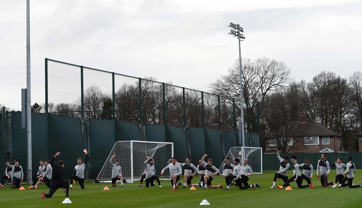Para pemain Liverpool melakukan pemanasan selama latihan di Melwood Training Ground di Liverpool, Inggris (3/4). Liverpool akan bertanding melawan klub senegaranya Manchester City pada leg pertama babak perempatfinal Liga Champions. (AFP Photo/Paul Ellis)