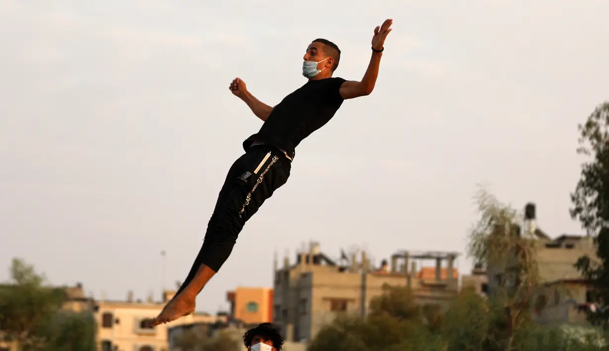 Seorang pemuda Palestina berlatih parkour selama pemberlakuan karantina wilayah (lockdown) di tengah wabah COVID-19, di Kota Khan Younis, Jalur Gaza selatan (18/9/2020). (Xinhua/Yasser Qudih)