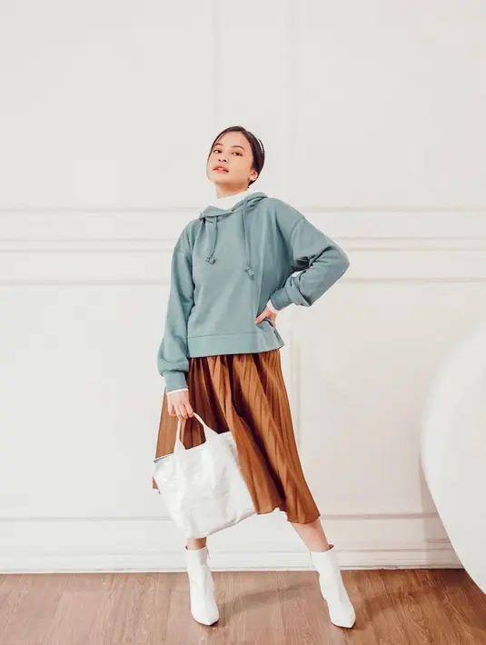Berikan sentuhan kesan feminin dengan padu padan hoodie tosca dan rok plisket warna coklat seperti OOTD Hanggini yang satu ini. Biar makin chic tambahkan sepatu boots dan totebag warna putih. (Instagram/hanggini).