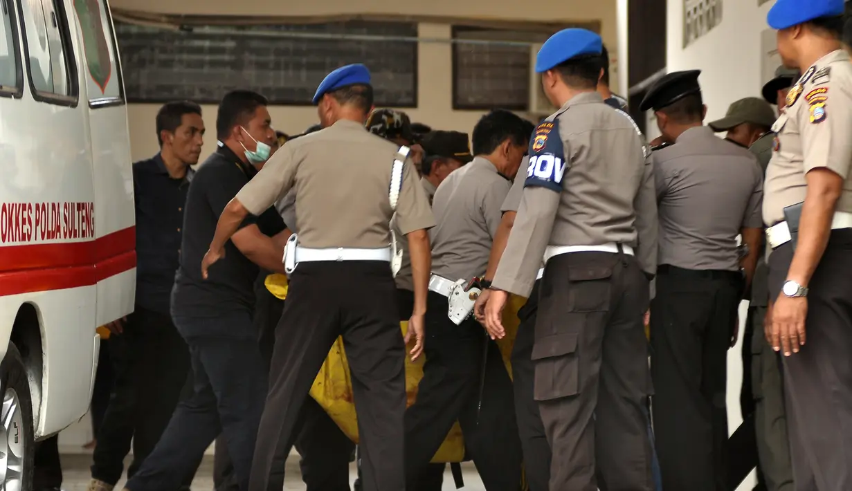 Petugas kepolisian membawa kantong jenazah masuk ke ruang jenazah di RS Bhayangkara Palu, Sulawesi Tengah, Selasa (17/7). Dua jenazah diduga teroris Santoso alias Abu Warda dan Muhtar yang tewas dalam baku tembak itu akan diidentifikasi. (OLAGONDRONK/AFP)