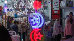 Orang-orang Palestina melihat toko yang menjual lampu hias ketika umat Muslim bersiap untuk memulai bulan suci Ramadan di Yerusalem timur, pada 21 April 2020. Beberapa jalanan di kota Yerusalem akan dihiasi dengan warna-warni lampu dan lentera untuk menyambut datangnya Ramadan. (Ahmad GHARABLI/AFP)