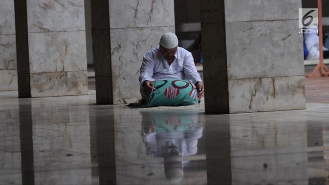 Umat muslim membaca pada hari ke-28 bulan suci Ramadan di pelataran Masjid Istiqlal, Jakarta, Selasa (12/6). Sejumlah umat muslim meningkatkan ibadah mereka dengan itikaf di Masjid Istiqlal jelang berakhirnya Ramadan. (Liputan6.com/Helmi Fithriansyah)