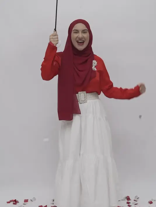 Irish Bella tampil mengenakan kerudung merah serasi dengan kemeja panjangnya, dipadukan rok panjang. [@_irishbella_]