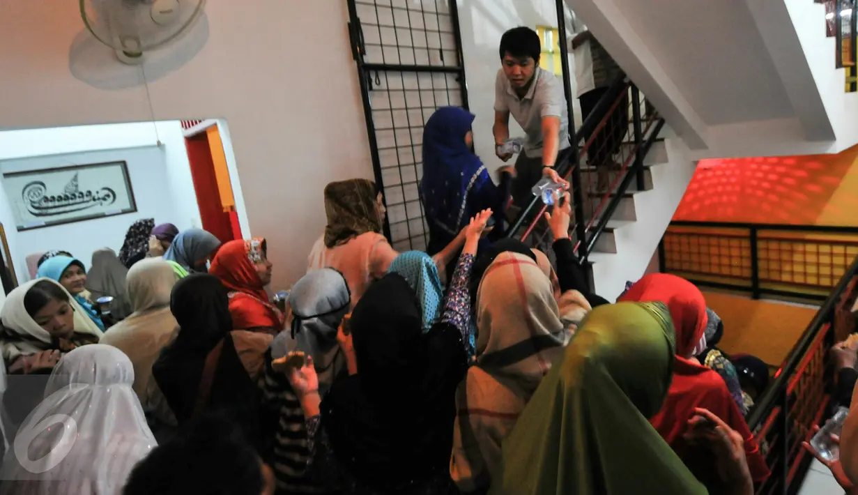 Pengurus Masjid Lautze membagikan takzil berbuka puasa untuk warga yang datang, Jakarta, Sabtu (11/6/2016). Selama bulan Ramadhan, Masjid Lautzd gelar buka puasa bersama untuk warga setiap hari Sabtu. (Liputan6.com/Yoppy Renato)