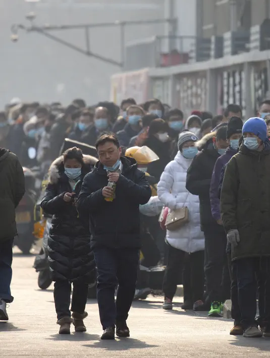 Orang-orang yang memakai masker pelindung berbaris untuk pengujian massal COVID-19 di Beijing, China, Jumat (22/1/2021). Beijing memerintahkan pengujian COVID-19 untuk sekitar dua juta orang menyusul kasus baru. (AP Photo/Mark Schiefelbein)