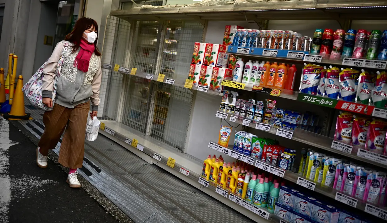 Seorang perempuan melewati stok tisu toilet yang habis di sebuah toko di Tokyo, Minggu (1/3/2020). Warga Jepang yang sedang waspada wabah virus corona tipe baru, Covid-19 dilanda kepanikan setelah muncul gosip bahwa China tidak akan lagi mengekspor kertas toilet. (CHARLY TRIBALLEAU/AFP)