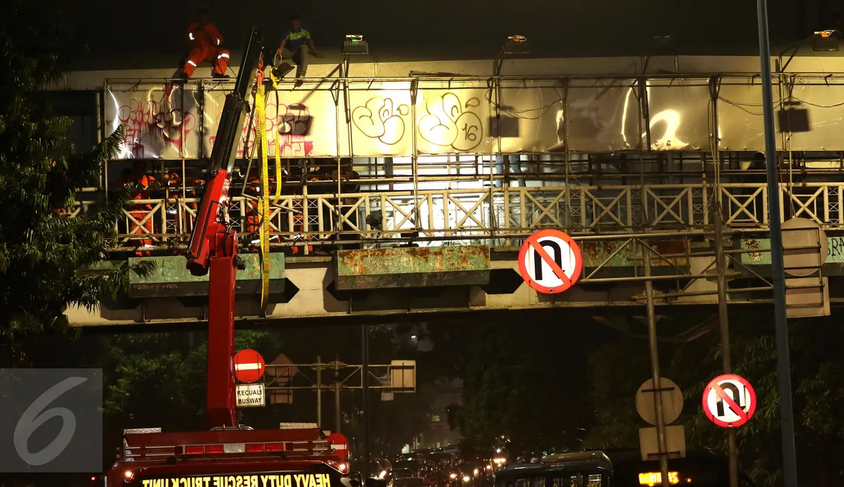 Petugas pemadam membongkar papan reklame di jembatan penyeberangan orang (JPO) di Jalan Warung Buncit Raya, Jakarta, Jumat (7/10). Dishub DKI akan membongkar 74 reklame lain yang berada di jembatan penyeberangan orang. (Liputan6.com/Helmi Afandi)