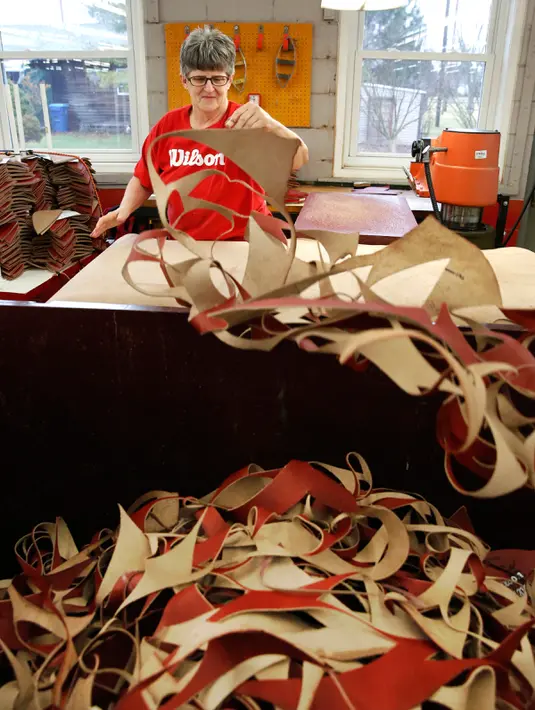 Pekerja Michelle Burkett memisahkan sisa bahan kulit bola American Football di pabrik Wilson Sporting Goods di Ada, Ohio, AS (11/1). (AP Photo/Charles Rex Arbogast)