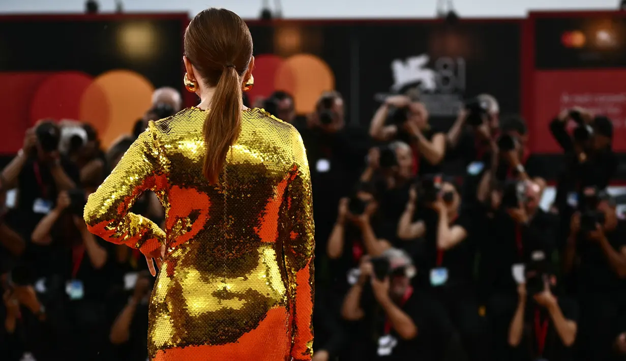Julianne Moore menambahkan aksesori anting-anting emas dengan aksen merah-oranye yang serasi dengan gaunnya, sementara ia menata rambut merahnya ke belakang. (Marco BERTORELLO / AFP)