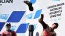 Pembalap Spanyol dari tim Repsol Honda, Marc Marquez (kanan) melempar sepatunya ke arah para penggemar usai Grand Prix MotoGP Australia di Sirkuit Phillip Island, Minggu (16/10/2022). Marc Marquez finish di posisi kedua dan ini menjadi podium pertamanya sejak kembali pasca operasi keempat cedera patah lengan tangan kanan. (Paul CROCK/AFP)