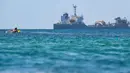 Seorang peselancar berenang menunggu ombak di Pantai Lhoknga, Kabupaten Aceh Besar, Provinsi Aceh, Indonesia, 20 Februari 2023. Pantai Lhoknga memiliki panorama cantik serta beberapa spot berselancar yang menantang. (CHAIDEER MAHYUDDIN/AFP)