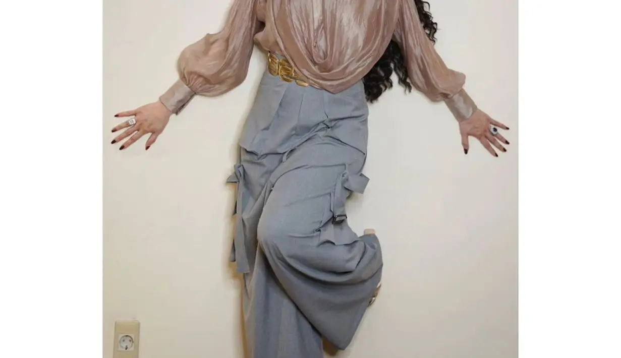 Melihat Reza Artamevia dibalut outfit yang lebih kasual. Atasan blouse cokelat dengan detail yang dramatis dipadu palazzo pants berkantung berwarna abu-abu. [Foto: Instagram/rezaartameviaofficial]