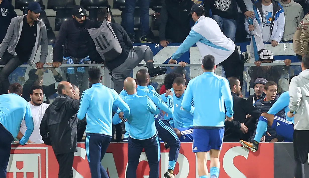 Rekan-rekan Patrice Evra berusaha memisahkan bek Olympique Marseille itu dan seorang suporter menjelang partai Liga Europa lawan Vitoria Guimaraes di Estadio D. Afonso Henriques, Jumat (3/11). Evra menendang suporter Marseille di kepala. (AP/Luis Vieira)