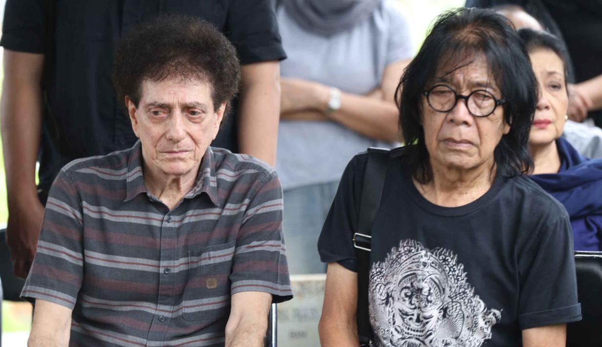 Semasa hidupnya, Donny Fattah dikenal sebagai sosok sentral dalam sejarah musik rock Indonesia. Tampak dalam foto, ekspresi vokalis grup band God Bless, Ahmad Albar (tengah) bersama Ian Antono (kanan) menyaksikan prosesi pemakaman jenazah Donny Fattah di Tempat Pemakaman Umum (TPU) Kampung Kandang, Jagakarsa, Jakarta Selatan, Sabtu (7/3/2026). (Kapanlagi.com/Budy Santoso)
