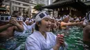 Penganut Shinto mandi dengan air dingin di Kuil Teppozu Inari, Tokyo, Jepang, 8 Januari 2023. Ritual Tahun Baru ini dilakukan untuk memurnikan jiwa dan raga. (Philip FONG/AFP)