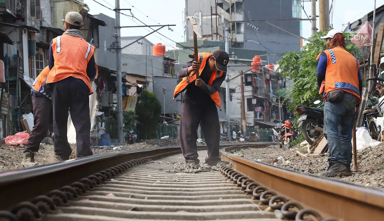 Pekerja menambahkan kerikil pada bantalan rel kereta di kawasan Roxy, Jakarta, Selasa (7/1). Penambahan kerikil tersebut dilakukan sebagai bentuk perawatan rutin agar perjalanan kereta tetap aman dan lancar. (Liputan6.com/Immanuel Antonius)